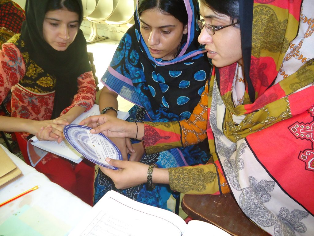 Three female health providers in Pakistan receiving training.